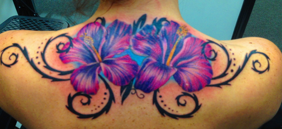Colorful flowers tattoo on a girl's shoulder and upper arm